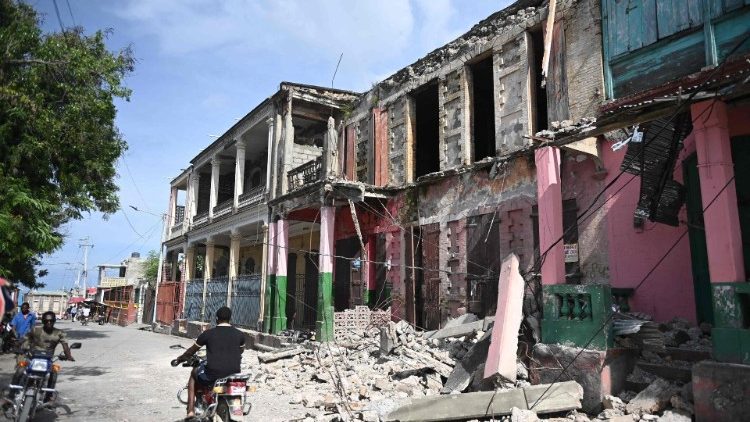 Pessoas passam por prédios danificados em Jeremie, Haiti, depois que um terremoto atingiu o oeste do Haiti. Um terremoto sacudiu partes do oeste do Haiti na terça-feira, matando pelo menos quatro pessoas e ferindo mais de duas dezenas, disseram autoridades de proteção civil. O terremoto de magnitude 4,9 ocorreu no departamento isolado de Grand'Anse, cerca de 300 km (185 milhas) a oeste de Port-au-Prince, a uma profundidade relativamente rasa de 10 km, de acordo com o US Geological Survey. (Foto de Richard PIERRIN/AFP)