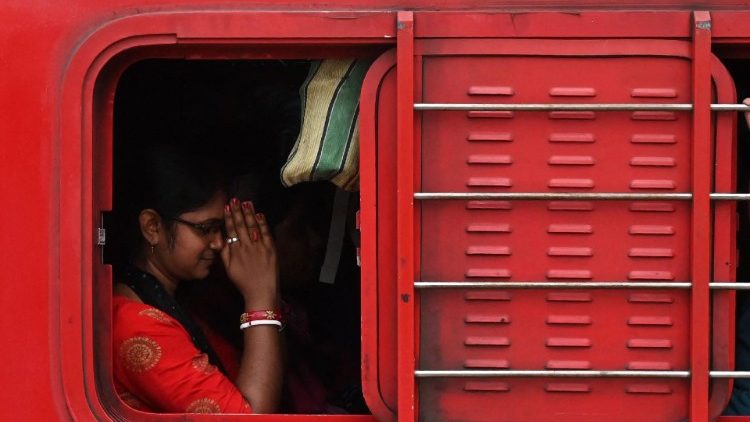 Une passagère prie à bord d'un train à proximité de Calcutta, le 7 juin 2023. 
