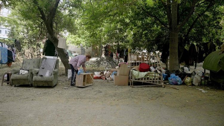 Kobieta wyciągająca na zewnątrz podniszczone rzeczy z jej mieszkania, które dotknęła powódź spowodowana wysadzeniem zapory w Nowej Kachowce, Chersoń, 21 czerwca 2023