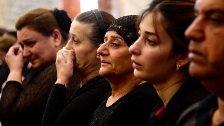 Mourners attend a mass for the victims of the wedding hall fire in Qaraqosh
