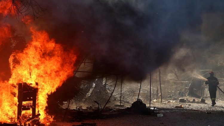 A fireman fights the flames at the Moria refugee camp in Greece