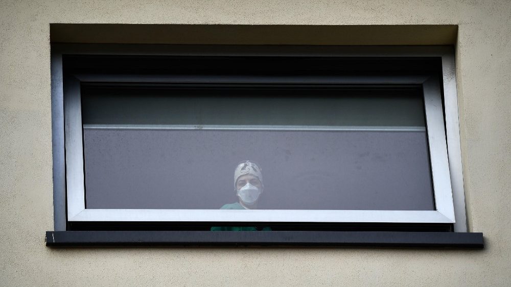 Enfermeiras e doentes acompanham oração das janelas dos hospital