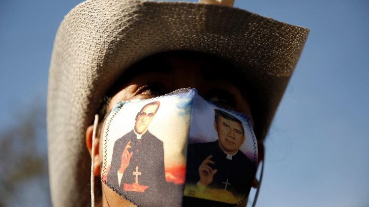 Salvadorenho usa máscara protetora com imagem de Santo Oscar Romero e Rutílio Grande
