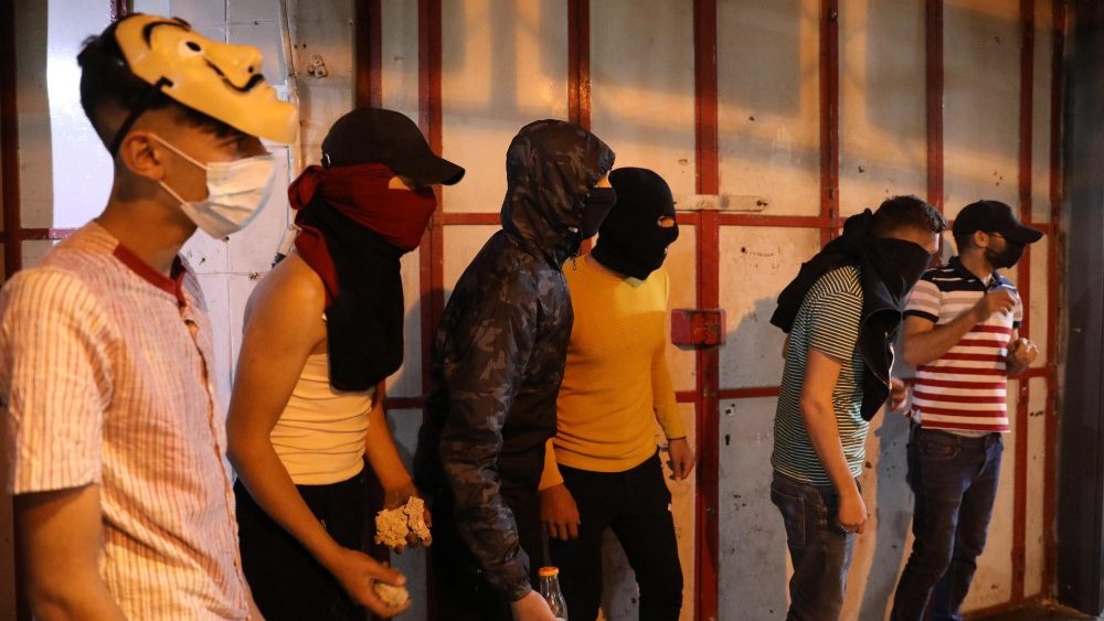 Manifestantes palestinos entram em confronto com tropas israelenses no centro da cidade de Hebron, na Cisjordânia, 12 de maio de 202