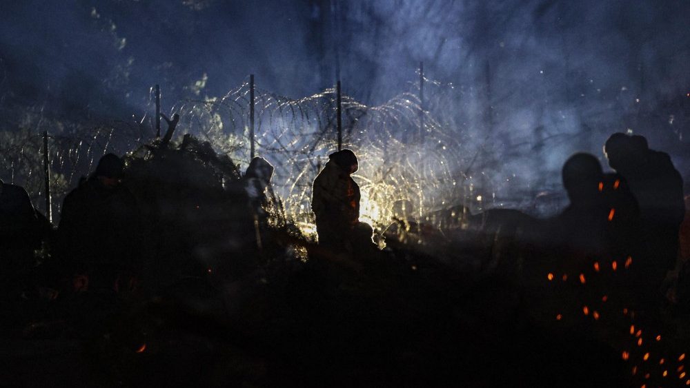 Migrantes se aquecem em seu acampamento na fronteira Belarus-Polônia na região de Grodno, Bielorrússia, 10 de novembro de 2021. (EPA / STRINGER)