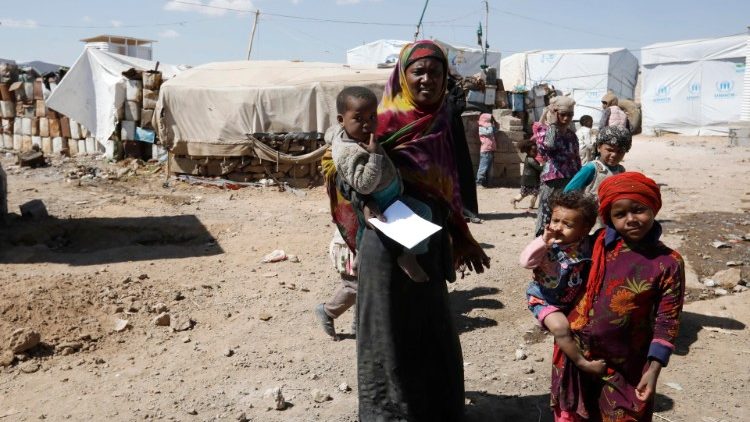 Yemenis outside makeshift shelters at a camp for internally displaced persons (IDPs) on the outskirts of Sana'a