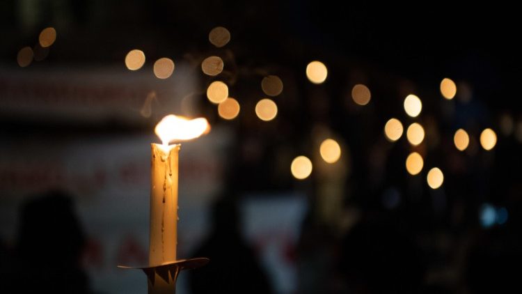 Candlelight flickers in the darkness in a sign of peace