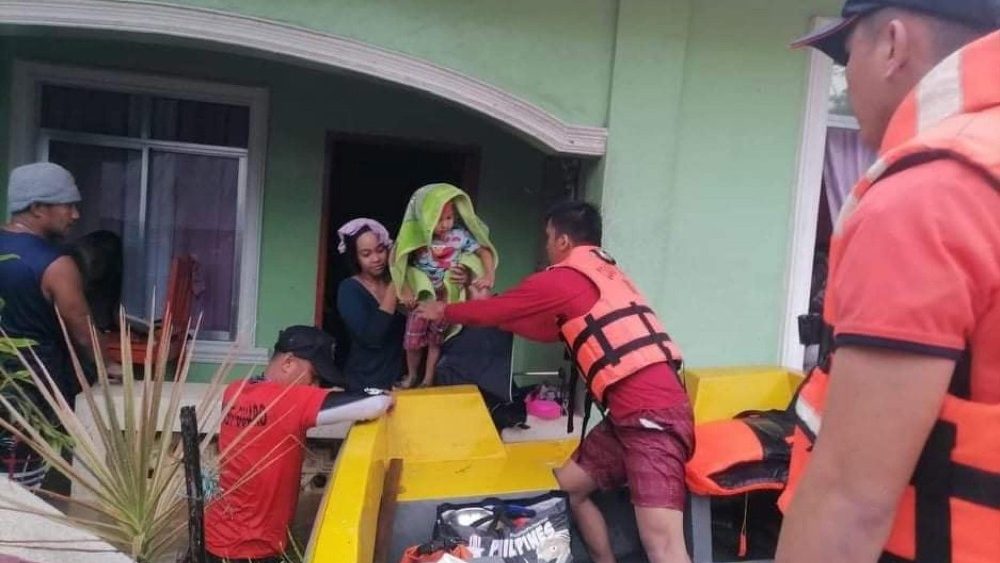 Foto disponibilizada pela Guarda Costeira das Filipinas (PCG) mostra socorristas ajudando pessoas em uma balsa em uma vila inundada em Sigma, província de Capiz, Filipinas, 12 de abril de 2022 . Megi é o primeiro distúrbio climático a atingir o país este ano.  EPA/PCG