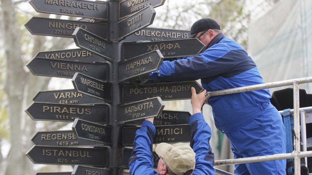 Trabalhadores retiram placas com os nomes de cidades russas, que eram cidades gêmeas de Odesa, do sinal memorial de cidades irmãs instalado perto do gabinete do prefeito em Odesa, Ucrânia, 14 de abril de 2022. EPA/STEPAN FRANKO