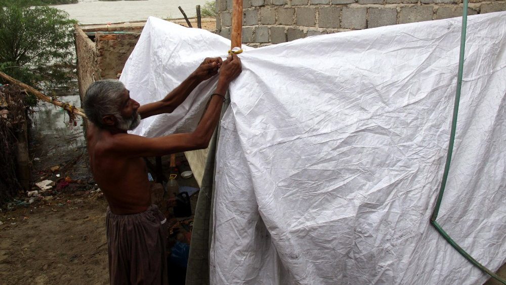 Pessoas afetadas por inundações cobrem seus acampamentos improvisados com folhas de plástico enquanto chove, em Hyderabad, província de Sindh, Paquistão, 12 de setembro de 2022.EPA/NADEEM KHAWAR