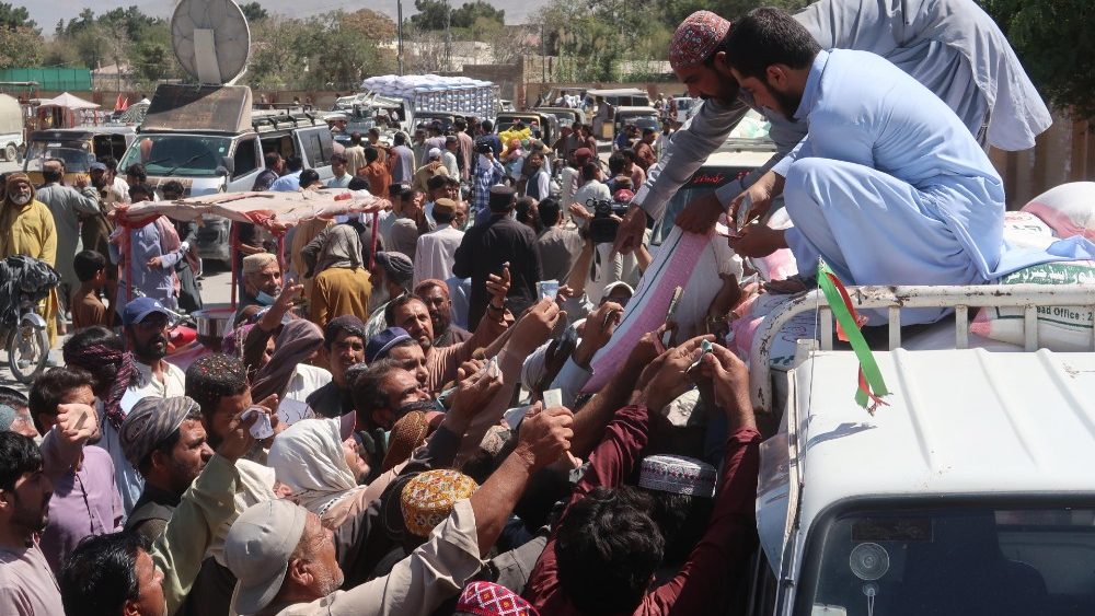 As pessoas fazem fila para comprar farinha de trigo a preços controlados, pois devido às inundações, a escassez de trigo afetou o fornecimento de farinha de trigo, uma dobra básica nas famílias paquistanesas, em Quetta, província do Baluchistão, Paquistão, 21 de setembro de 2022.. EPA/FAYYAZ AHMAD