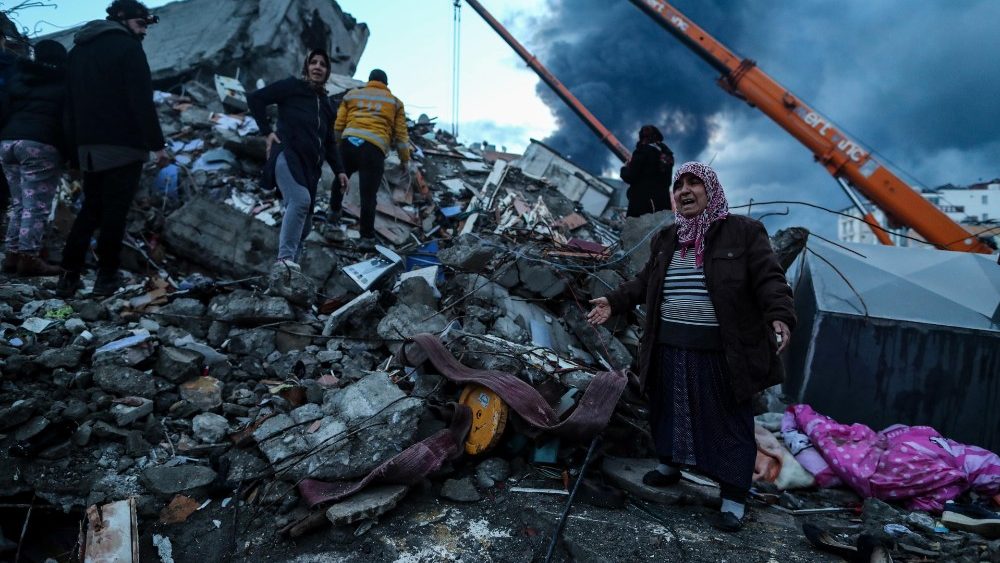 Uma mulher reage enquanto equipes de emergência realizam uma operação de busca e resgate no local de um prédio que desabou após um terremoto em Iskenderun, distrito de Hatay, Turquia, 07 de fevereiro de 2023. EPA/ERDEM SAHIN