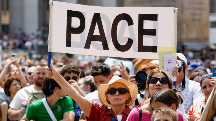 Gläubige halten ein Plakat mit einem Friedensaufruf hoch