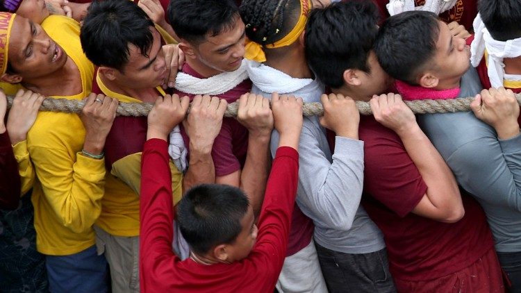 Catholic devotees hold on to a rope to get closer to touch the statue of the Black Nazarene on its feast day in Manila