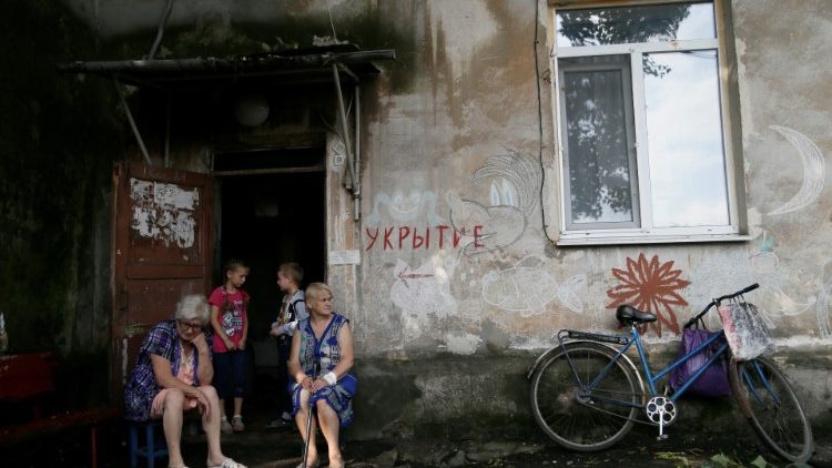 Local residents outside a bloc of flats in a Donetsk suburg in easter Ukraine. The sign reads "Shelter".