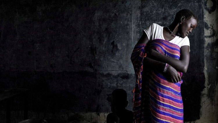 A displaced woman and a child (hiding behind her dress) at a camp for IDPs after floods forced hundreds of thousands to leave their homes in Boma State, South Sudan 