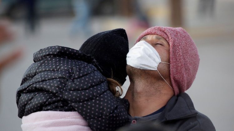 Migrante centro-americano carrega sua filha no México, fronteira com os Estados Unidos