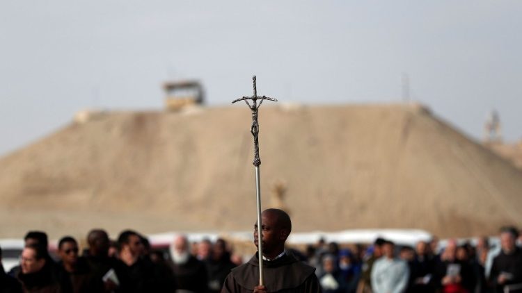 Franciscanos e fiéis católicos caminham em direção ao rio Jordão, para participar de uma cerimônia de batismo no local Qasr el-Yahud, perto de Jericó, na Cisjordânia ocupada por Israel