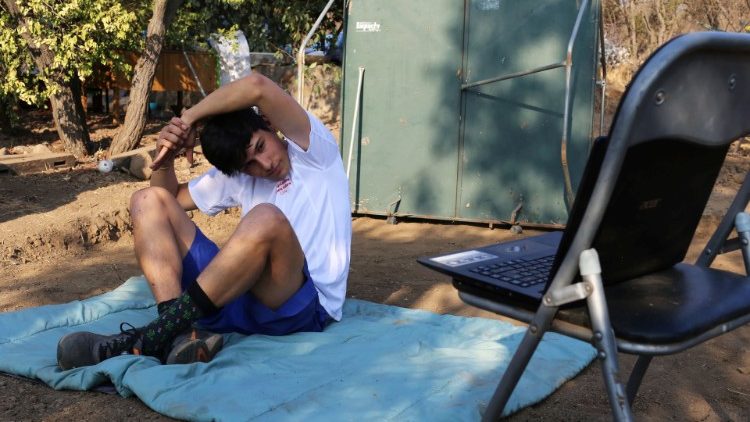 A Special Olympics athlete uses a laptop to follow an online physical activity program