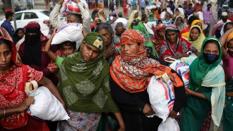 Women carry relief supplies provided by local police authority amid the coronavirus disease (COVID-19) outbreak in Dhaka