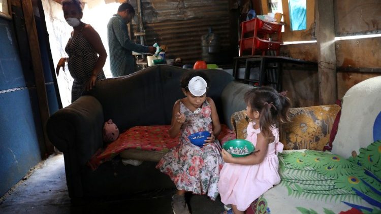 One of many families settled in a house made with mud, sticks and tin sheet, at a vacant lot since they cannot afford to pay rent anymore in the municipality of Sucre