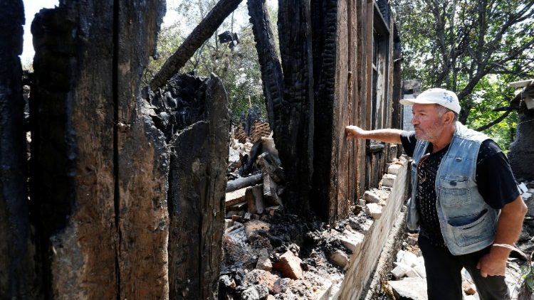 A resident beside a house destroyed by shelling in the Ukrainian city of Donetsk, 22 July