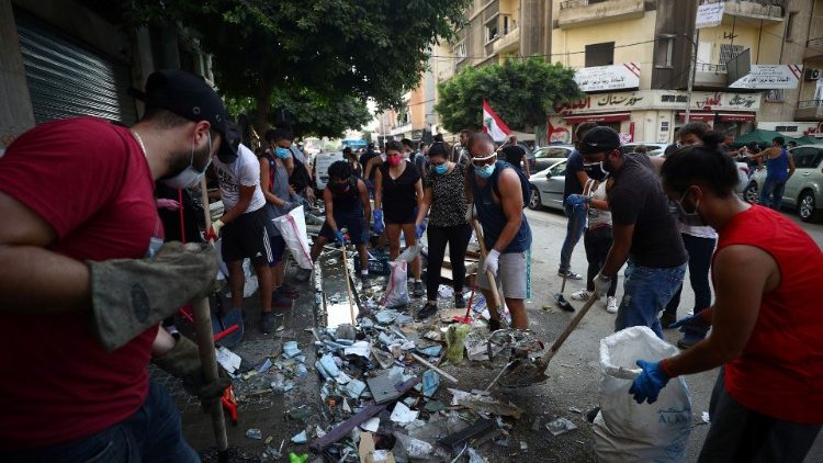 People clear a street new site of Tuesday's blast