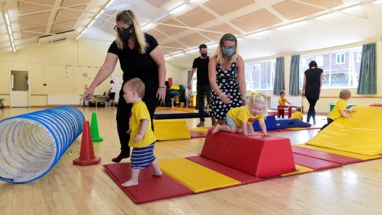 Children accompanied by adults participate in "Tumble Tots" play activity in Gloucester