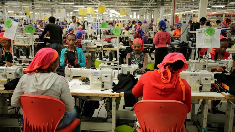 FILE PHOTO: Workers sew clothes in a textile factory 