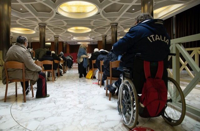 A group of homeless people looked after by structures run by the Offices of Papal Charities wait to be vaccinated