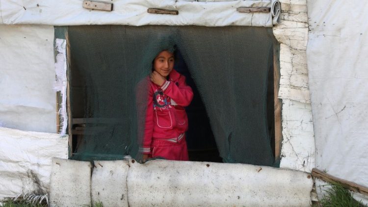 Refugiada síria olha de uma tenda, montada para receber refugiados no Vale de Bekaa