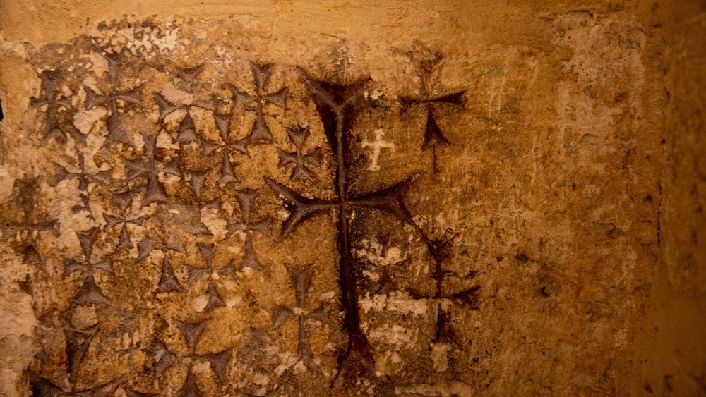 Cruzes gravadas na antiga parede de pedra da capela de Santa Helena são vistas dentro da Igreja do Santo Sepulcro na Cidade Velha de Jerusalém