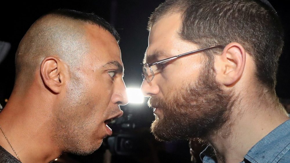 Um manifestante palestino enfrenta um colono judeu em meio a uma tensão contínua antes de uma audiência em tribunal em uma disputa de propriedade de terras entre israelenses e palestinos no bairro de Sheikh Jarrah em Jerusalém Oriental em 5 de maio de 2021. REUTERS / Ammar Awad