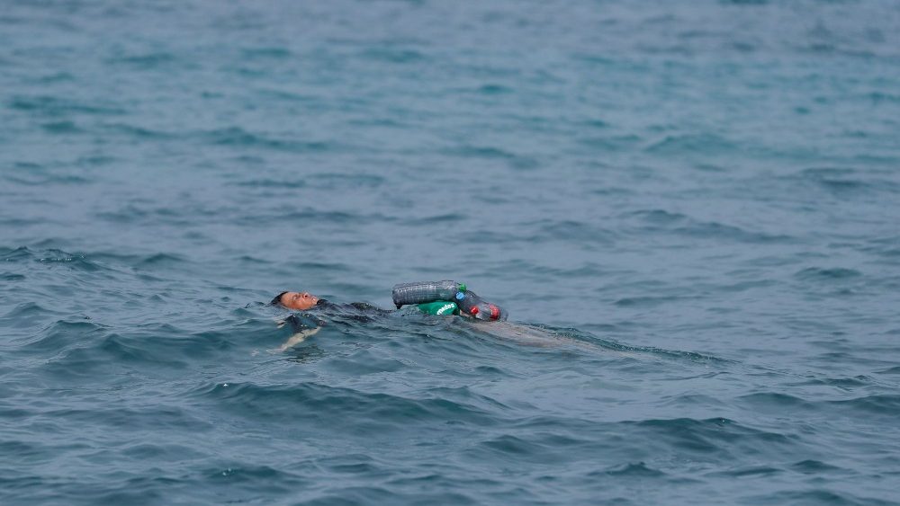 Jovem marroquino usa garrafas como bóia, próximo à cerca entre a fronteira hispano-marroquina, REUTERS / Jon Nazca