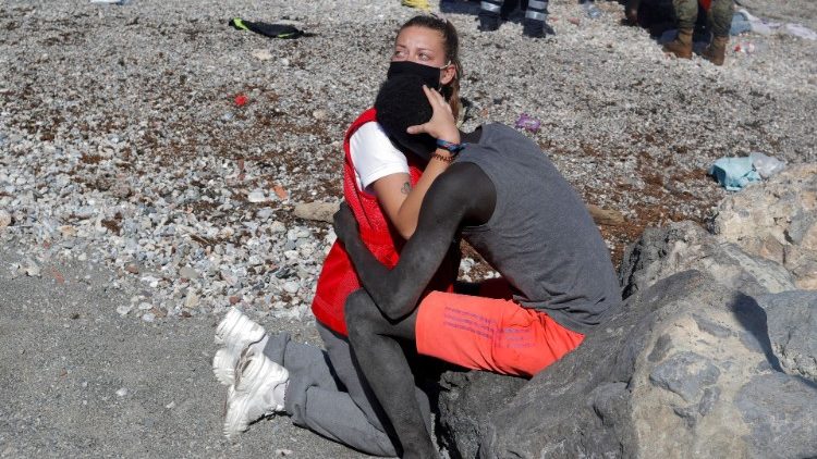 Luna Reyes, 20 anos, membro da Cruz Vermelha Espanha, abraça e conforta migrante proveniente da África Subsaariana que chegou a nado à praia de El Tarajal, 