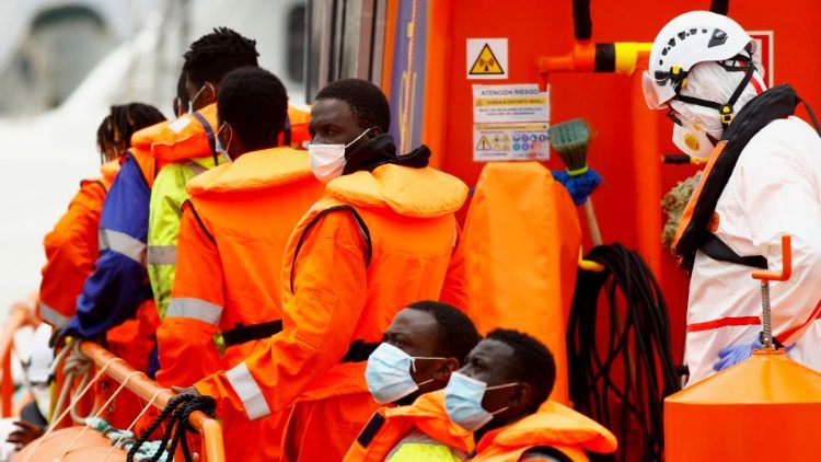 Migranti in attesa di sbarcare da una motovedetta dalla Guardia costiera