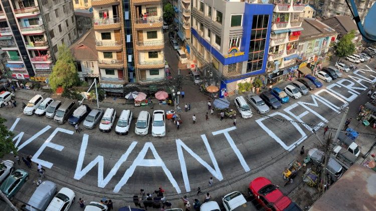 Slogan pedindo democracia escrito em uma rua de Yangon
