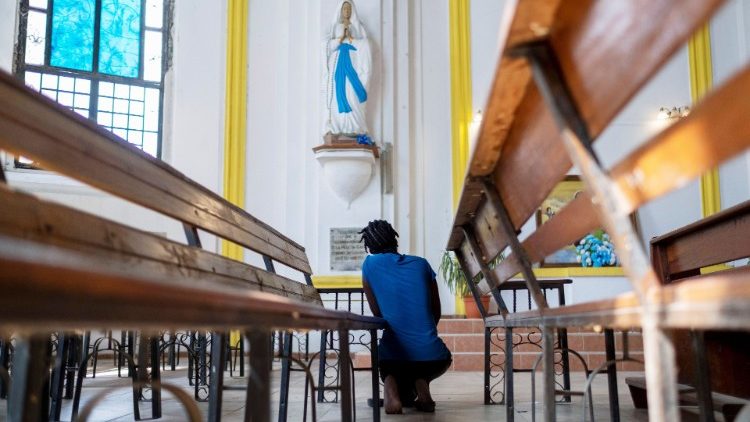 Haitiana reza diante de uma imagem da Virgem Maria durante o velório do presidente haitiano Jovenel Moise na Catedral de Notre Dame em Cap-Haitien, Haiti, 22 de julho de 2021. (REUTERS / Ricardo Arduengo)