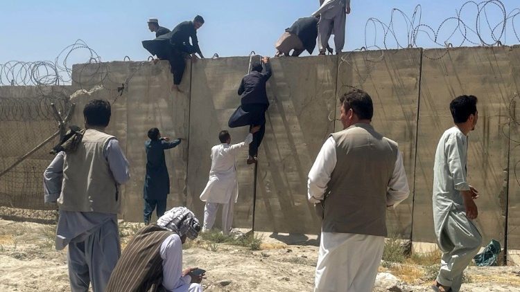 Hombres tratando de ingresar en el Aeropuerto Internacional Hamid Karzai de Kabul