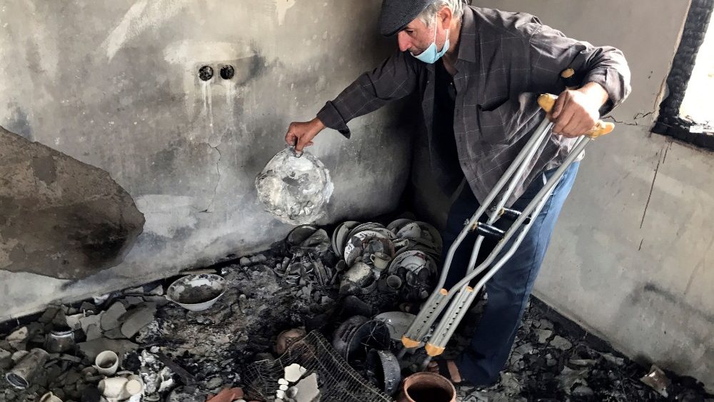 Lyazid Tazibt shows damaged belongings inside his home that was burnt following a wildfire in the village of Ait Sid Ali