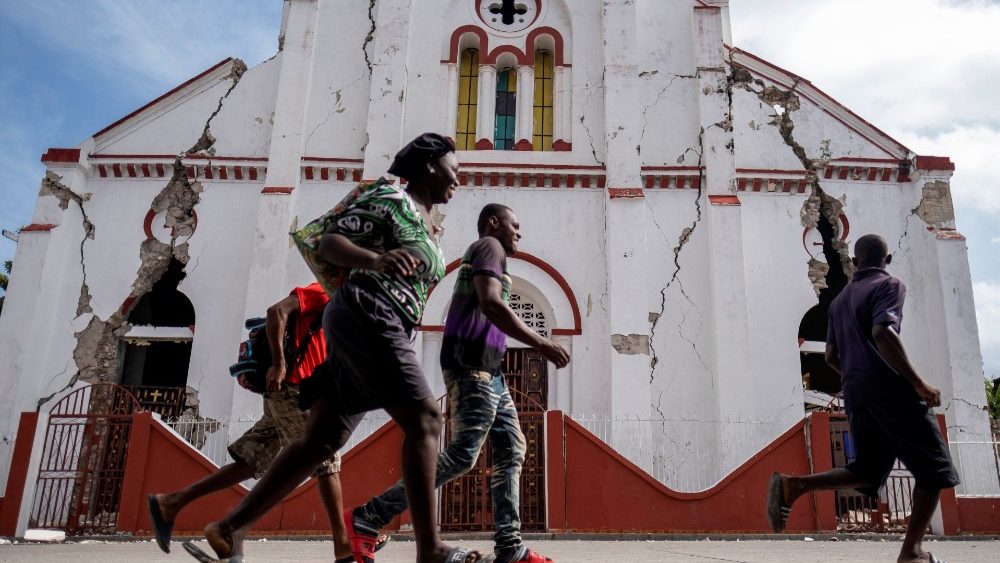 Pessoas passam correndo em frente a uma igreja fortemente danificada após o terremoto de magnitude 7,2 em Les Cayes, Haiti, 18 de agosto de 2021. REUTERS / Ricardo Arduengo