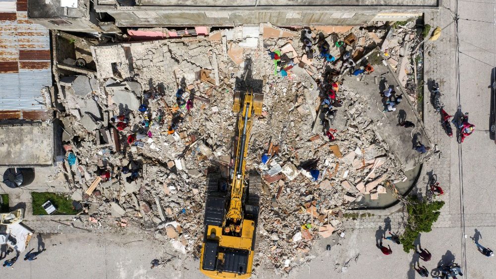 Haitianos observam escavadeira que remove entulho de um prédio destruído após o terremoto de magnitude 7,2 em Les Cayes, Haiti, 18 de agosto de 2021. REUTERS / Ricardo Arduengo