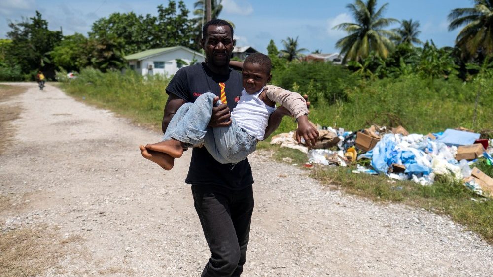 Haitiano carrega menino ferido após o terremoto para receber atendimento médico no Hospital Ofatma, em Les Cayes, Haiti, 18 de agosto de 2021. REUTERS / Ricardo Arduengo