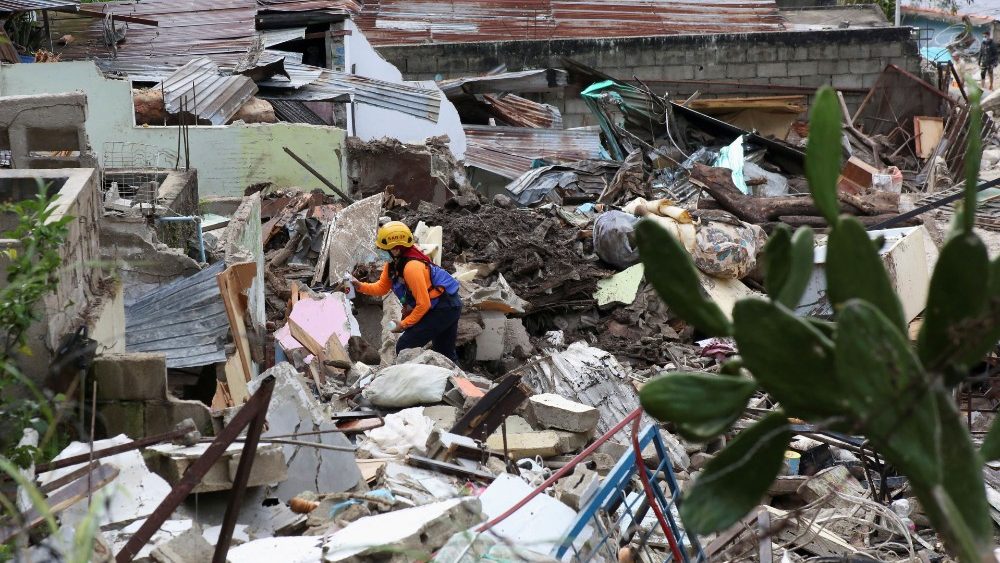 Membro da Proteção Civil vasculha destroços em Tovar, estado de Mérida. (REUTERS / Carlos Eduardo Ramirez)