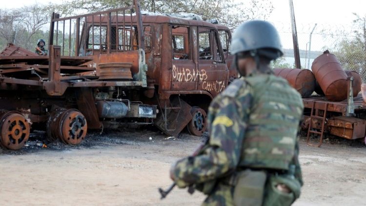 Ein Soldat der ruandischen Sicherheitskräfte vor einem verbrannten Lastwagen im Hafen von Mocimboa da Praia