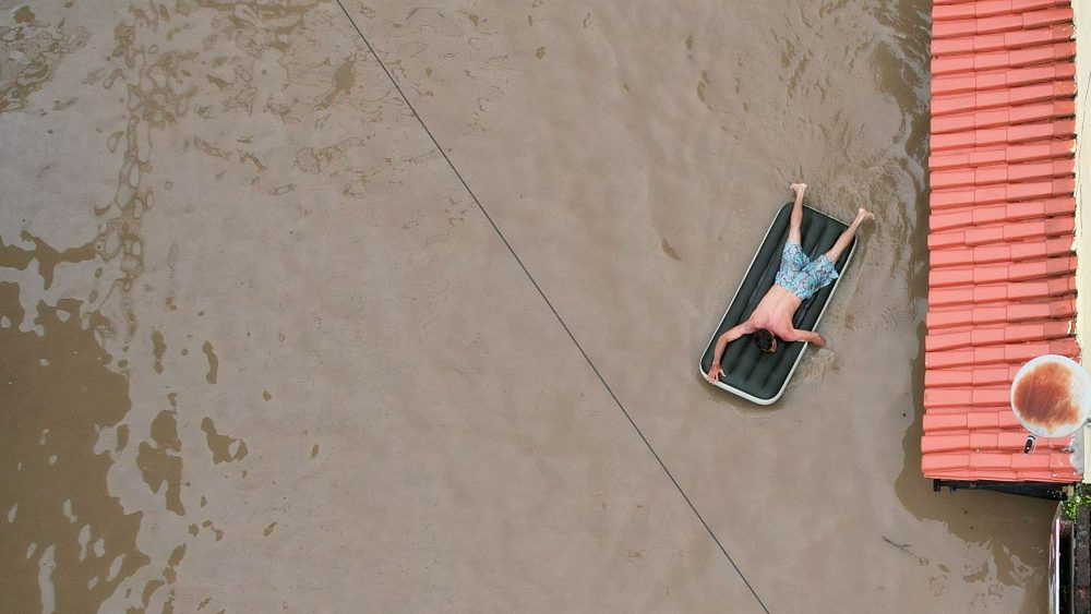 Homem usa colchão inflável durante inundação em Itabuna, uma das cidades mais atingidas no sul da Bahia (Reuters)