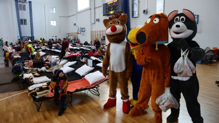 Voluntários vestidos com personagens de animais caminham dentro de um pavilhão esportivo de uma escola primária, transformada em acomodação temporária para pessoas que fogem da invasão russa da Ucrânia, para entreter filhos de refugiados em Przemysl, Polônia, 19 de março de 2022. REUTERS/Fabrizio Bensch