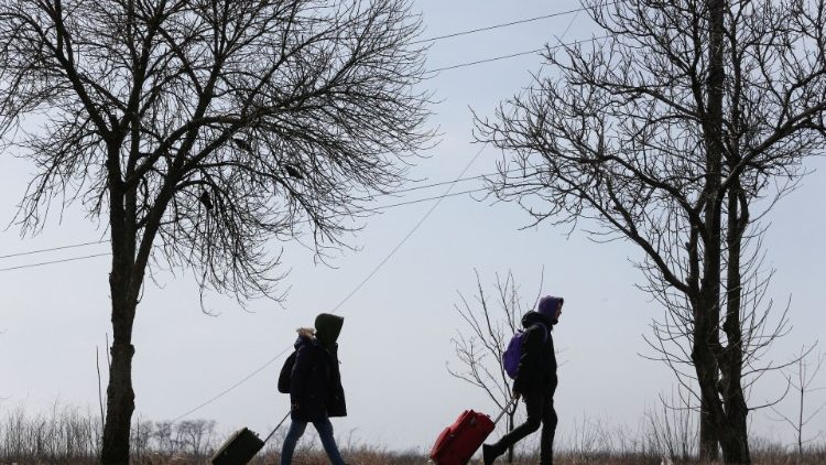 Refugiados caminham ao longo de uma estrada fugindo da guerra em Maiupol. REUTERS/Alexander Ermochenko