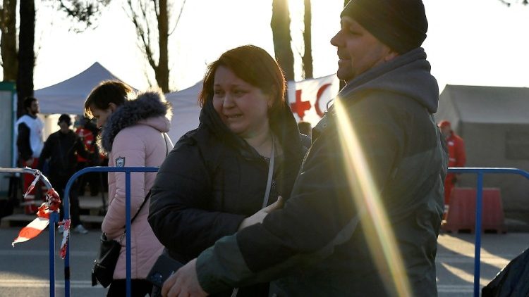 A woman looks back at her daughter running towards her husband after fleeing from Kharkiv in Ukraine to Romania, following Russia's invasion of Ukraine, at the border crossing in Siret, Romania, March 21, 2022. REUTERS/Clodagh Kilcoyne