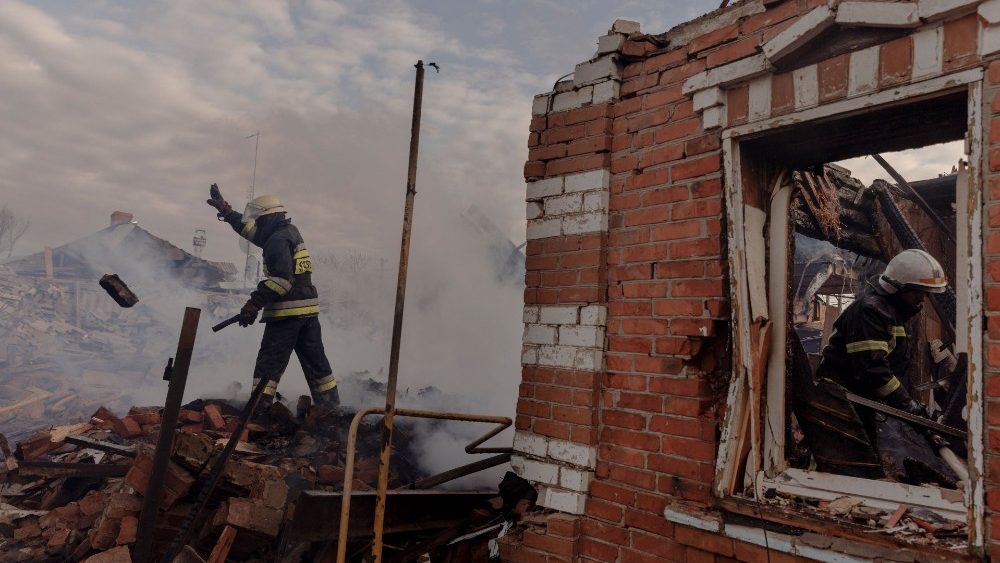 Bombeiros trabalham em meio aos escombros de casas residenciais que foram destruídas durante bombardeios em um assentamento nos arredores de Kharkiv, enquanto o ataque da Rússia à Ucrânia continua, Ucrânia, 28 de março de 2022. Foto tirada em 28 de março de 2022. REUTERS/Thomas Peter